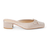 Vegan ivory satin heeled mule with a square toe, tonal bow detail, open back, and low block heel shown on a white background.