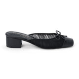 Vegan black mesh heeled mule with a square toe, tonal bow detail, solid toe cap, and low block heel shown on a white background.