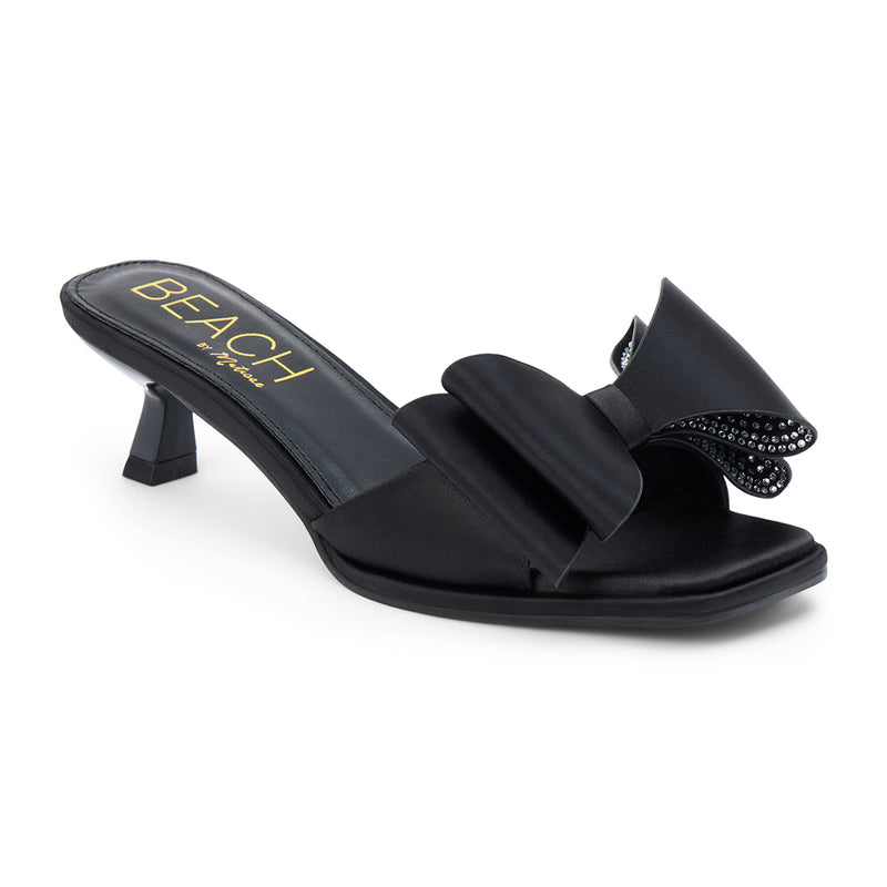 Holland Vegan Heeled Sandal – Beach by Matisse – Black satin slip-on sandal with kitten heel and oversized double bow detail.