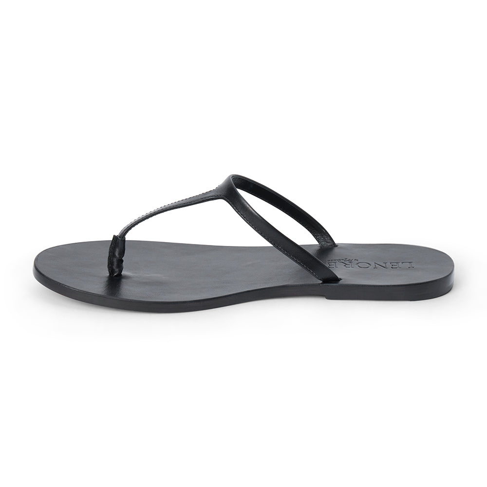 Black leather flat thong sandal with slim straps and minimalist design, shown on a white background.
