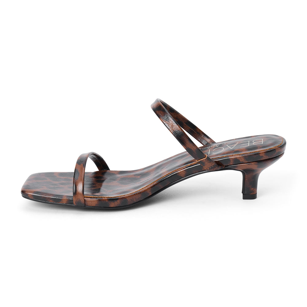 Vegan brown and black leopard-print faux leather sandal with slim straps, a square toe, and low kitten heel shown on a white background.