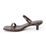 Vegan brown and black leopard-print faux leather sandal with slim straps, a square toe, and low kitten heel shown on a white background.
