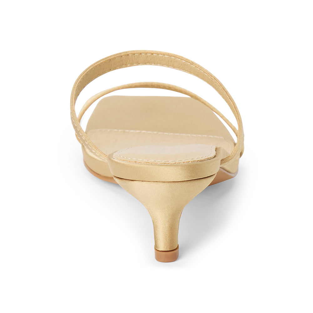 Vegan tan satin sandal with slim toe and instep straps, a square toe, and low kitten heel shown on a white background.