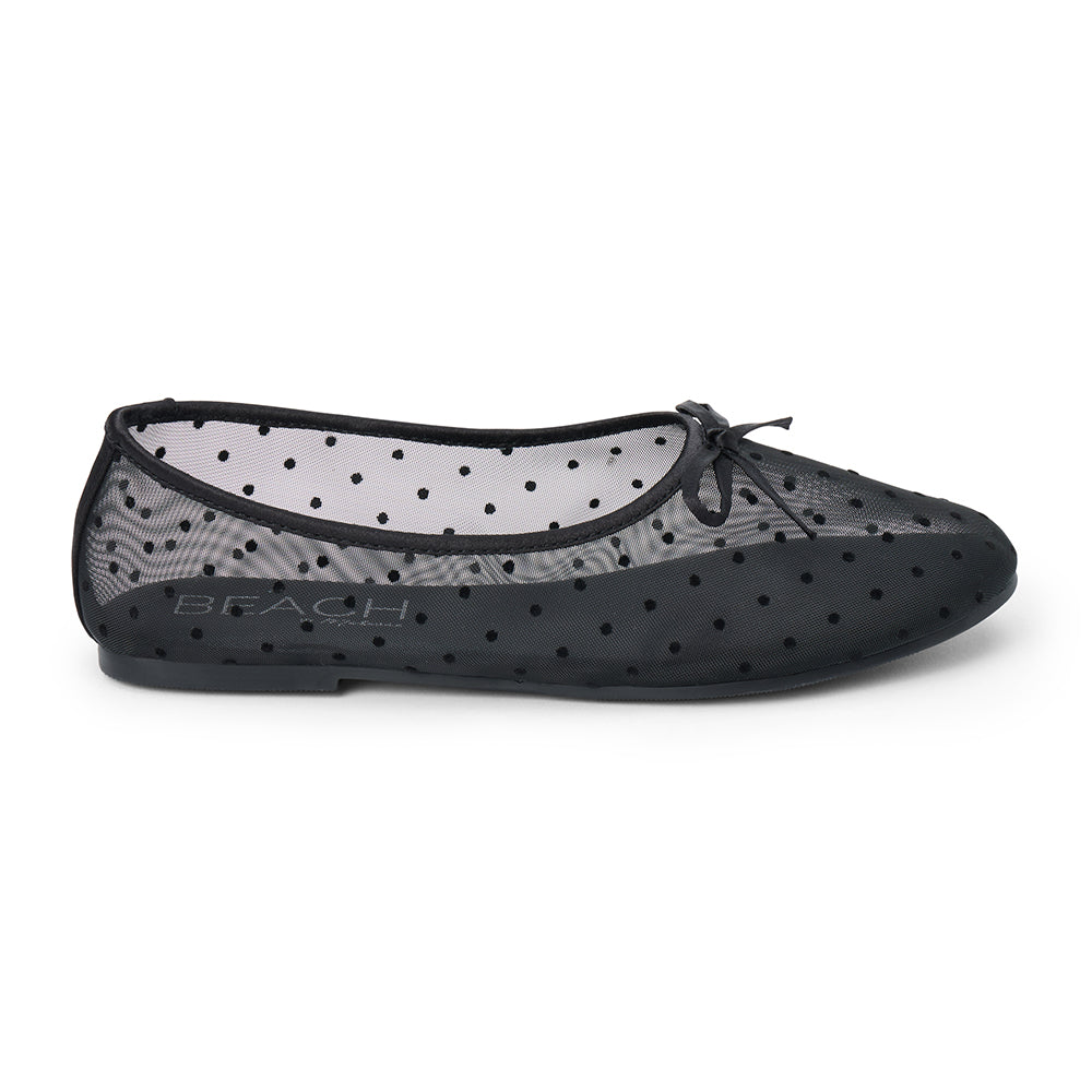 Vegan black sheer mesh ballet flat with black polka dots, a rounded toe, tonal trim, and small bow detail shown on a white background.