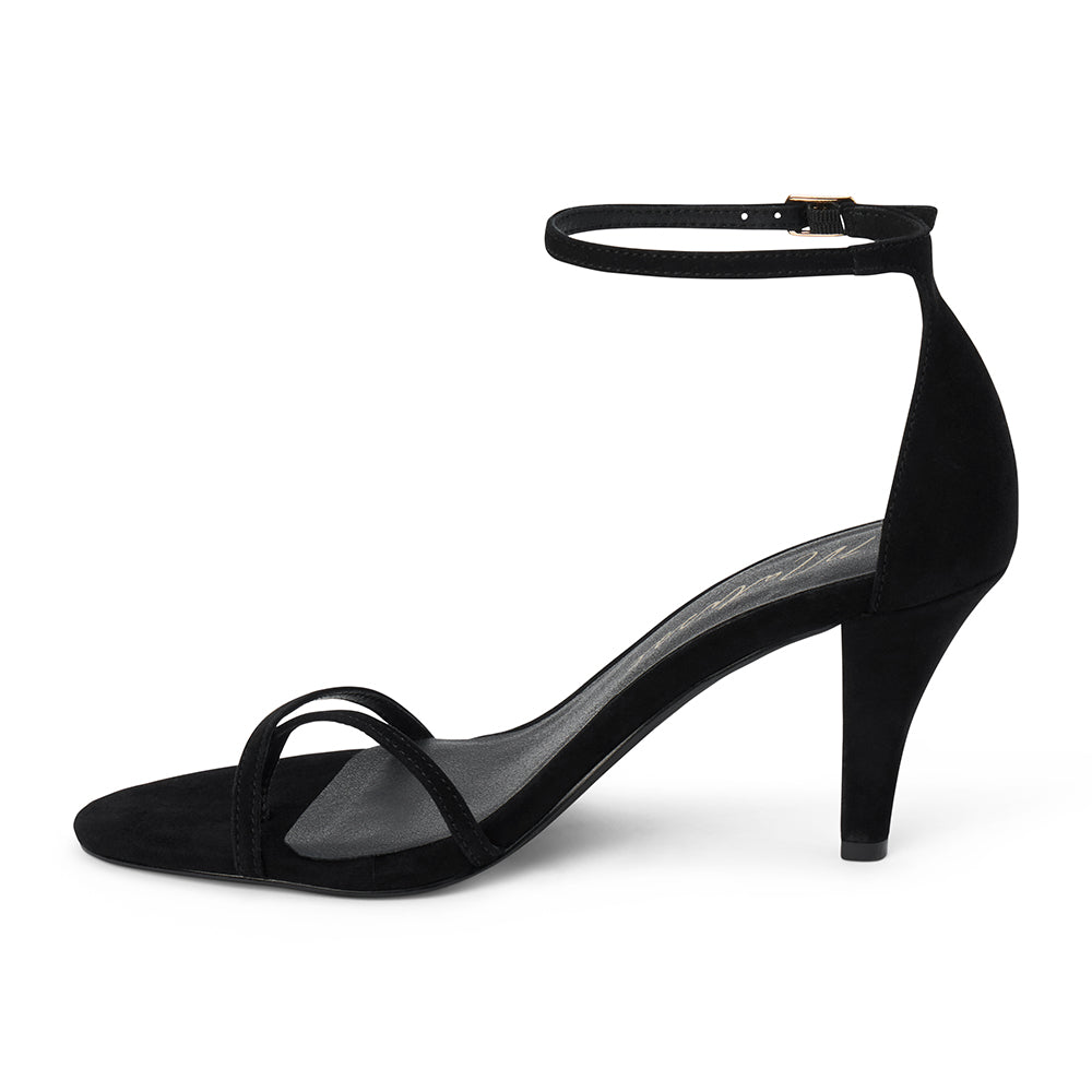 Black suede heeled sandal with a toe loop, slim ankle strap, and tapered heel shown on a white background.