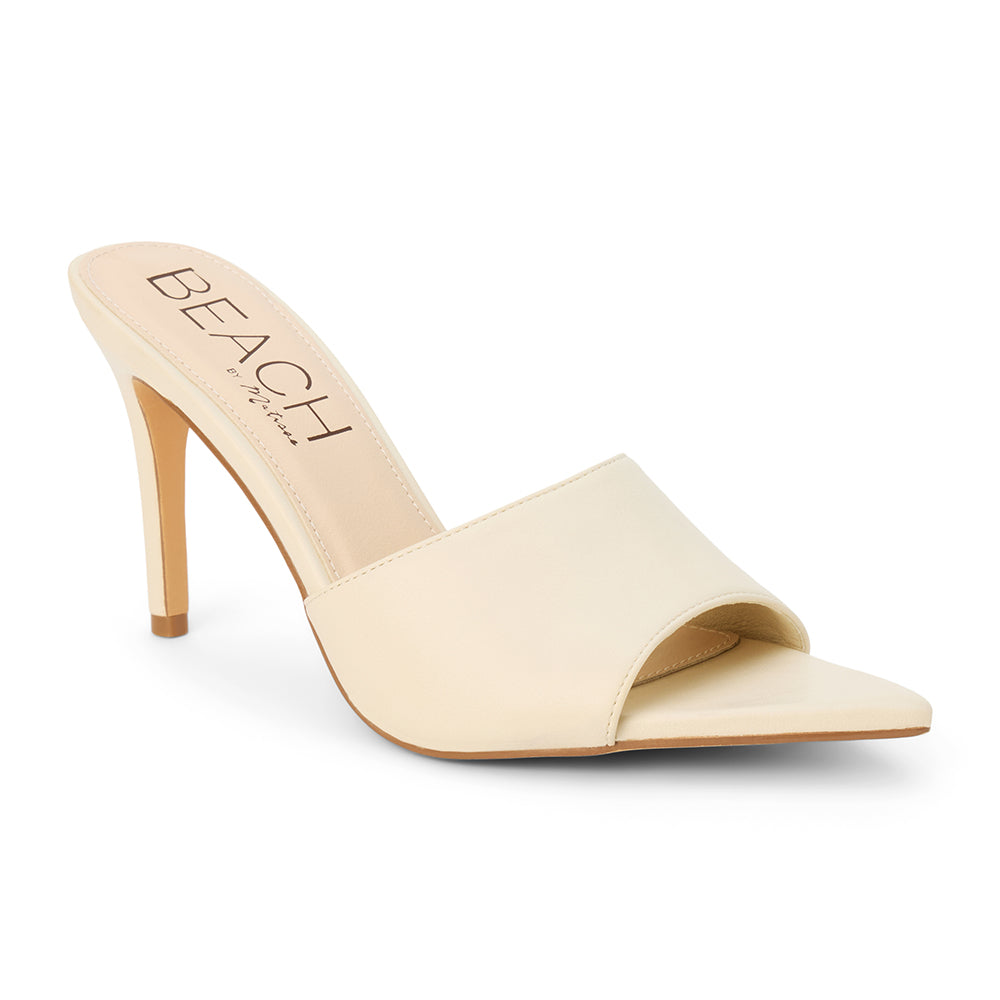 Ivory faux leather heeled sandal with a pointed toe, smooth upper, high heel, and slip-on design, shown on a white background.