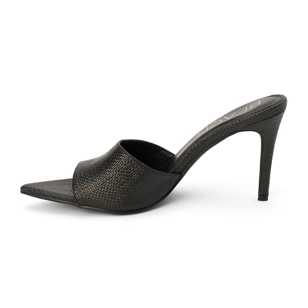 Black raffia heeled sandal with a pointed toe, woven upper, stiletto heel, and slip-on design, shown on a white background.