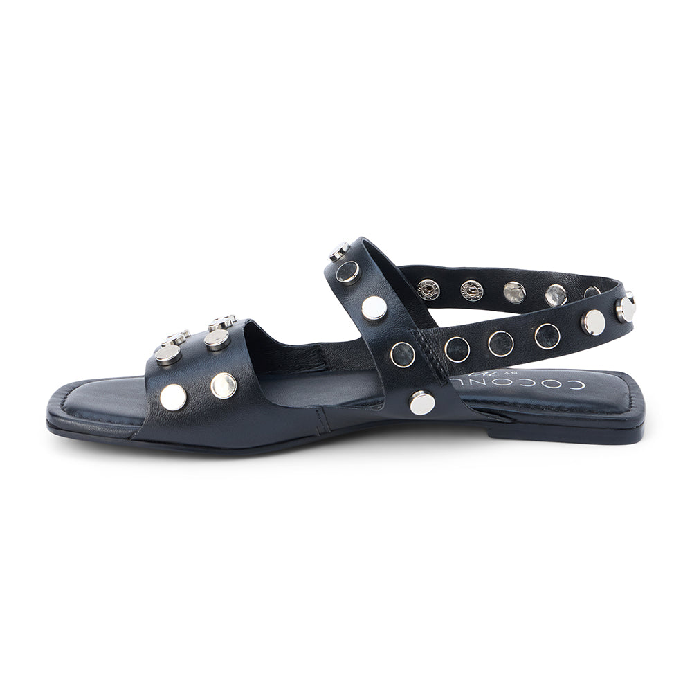 Black leather sandal with silver studs and slingback strap shown on a white background.