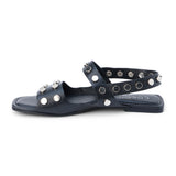 Black leather sandal with silver studs and slingback strap shown on a white background.
