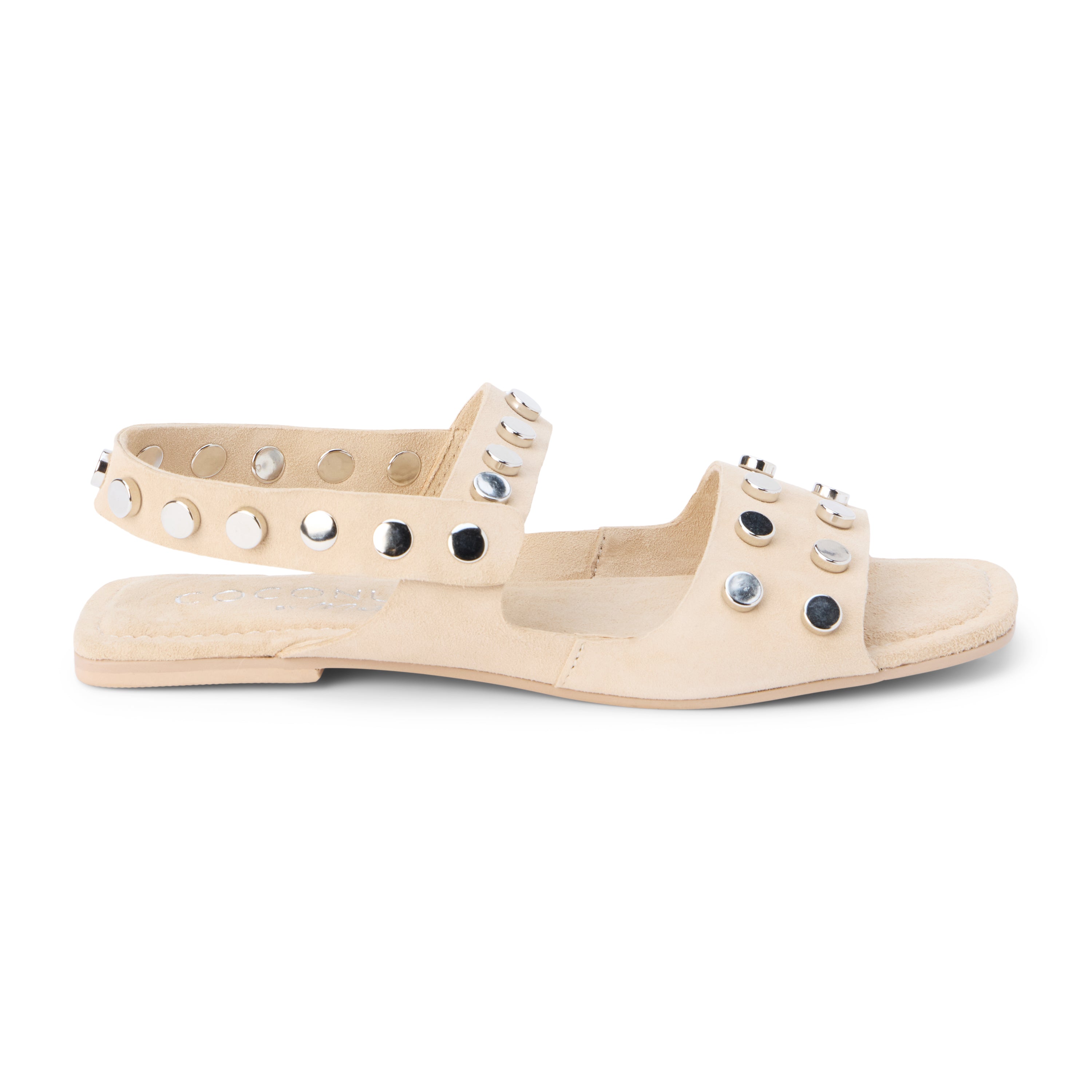 Ivory suede sandal with silver studs and slingback strap shown on a white background.