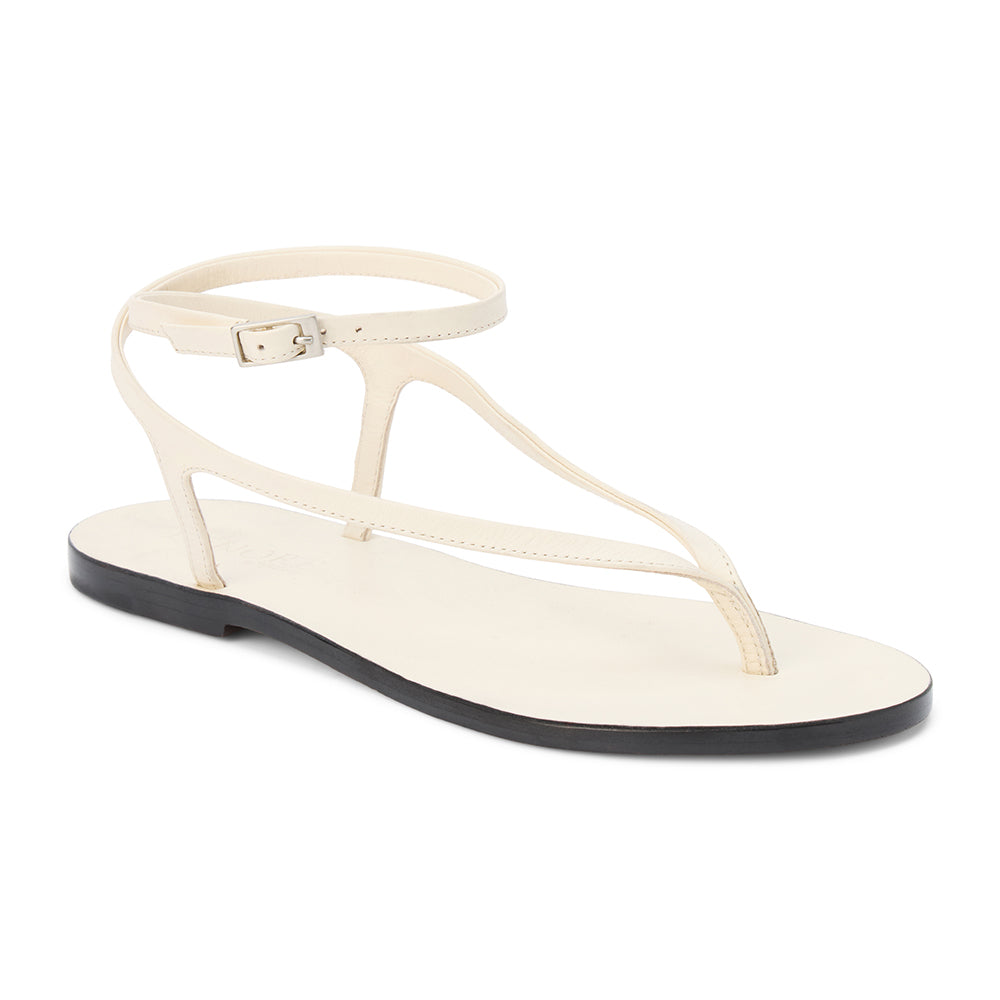 Ivory leather thong sandal with a minimalist strappy design and adjustable ankle buckle. A sleek and versatile style for effortless warm-weather dressing.