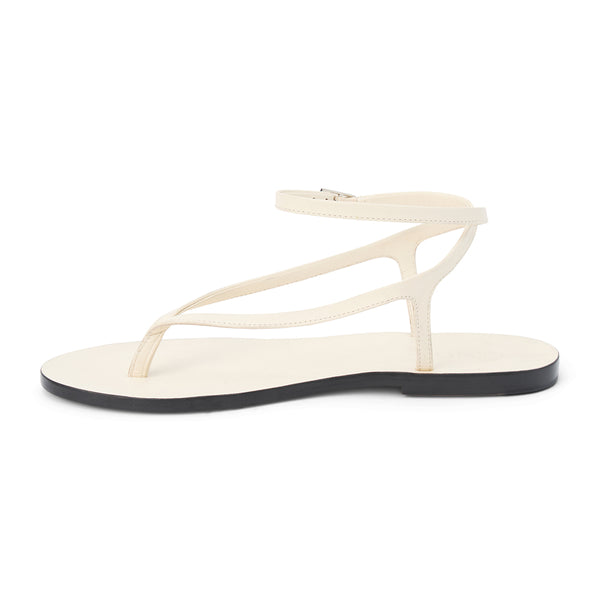 Ivory leather thong sandal with a minimalist strappy design and adjustable ankle buckle. A sleek and versatile style for effortless warm-weather dressing.