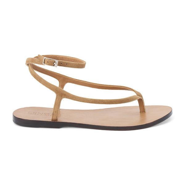 Light brown suede thong sandal with a minimalist strappy design and adjustable ankle buckle. A sleek and versatile style for effortless warm-weather dressing.