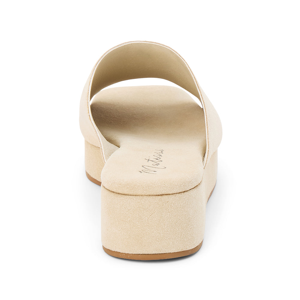 Light beige suede slide sandal with a wide single strap, open toe, platform sole, and slip-on design, shown in side profile on a white background.