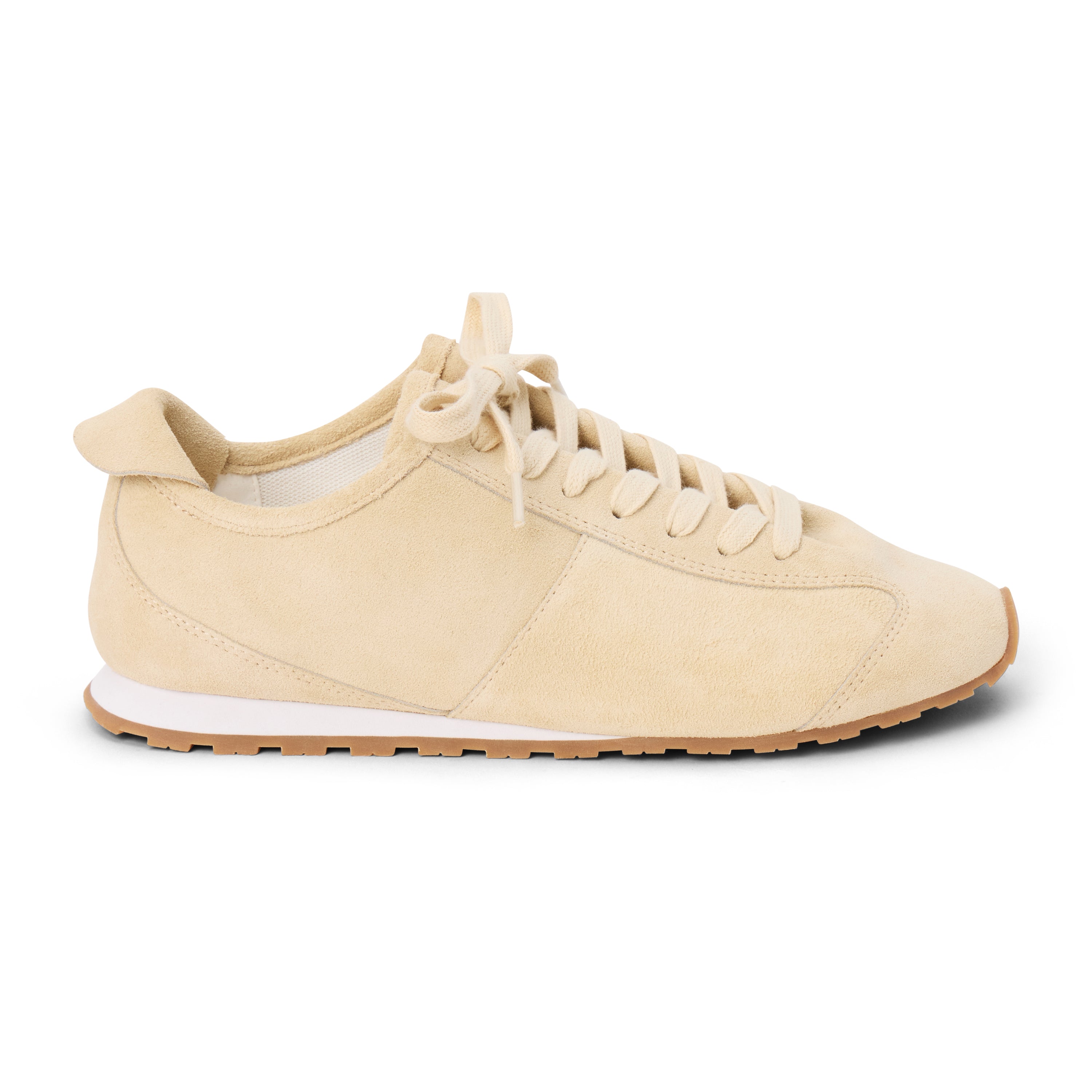 Ivory suede trainer with tonal laces, stitched paneling, a low-profile silhouette, white midsole, and gum outsole shown on a white background.