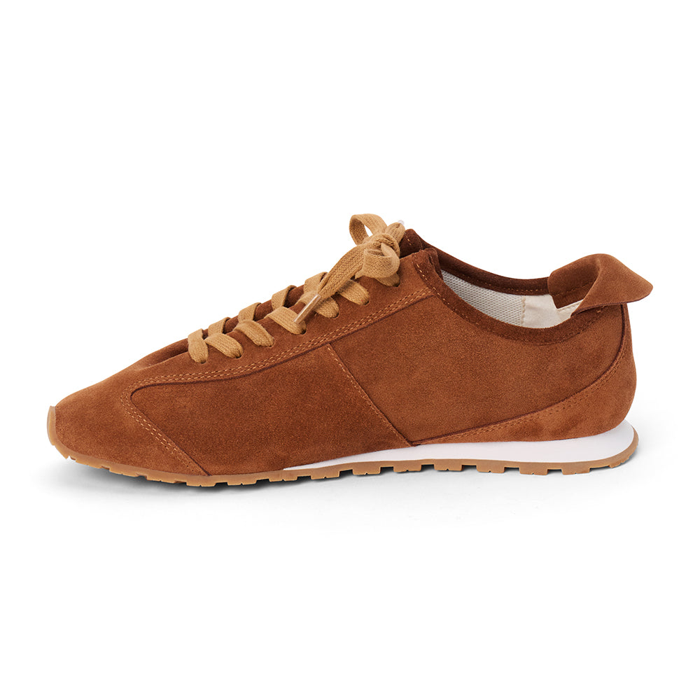 Brown suede trainer with tan laces, tonal paneling, a low-profile silhouette, white midsole, and gum outsole shown on a white background.