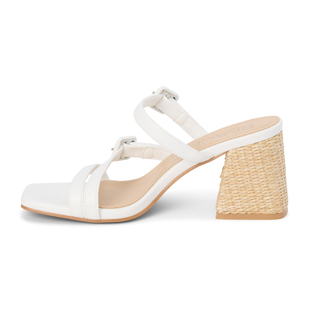 White faux leather sandal with adjustable buckle straps, open square toe, raffia-wrapped block heel, and slip-on design, shown on a white background.