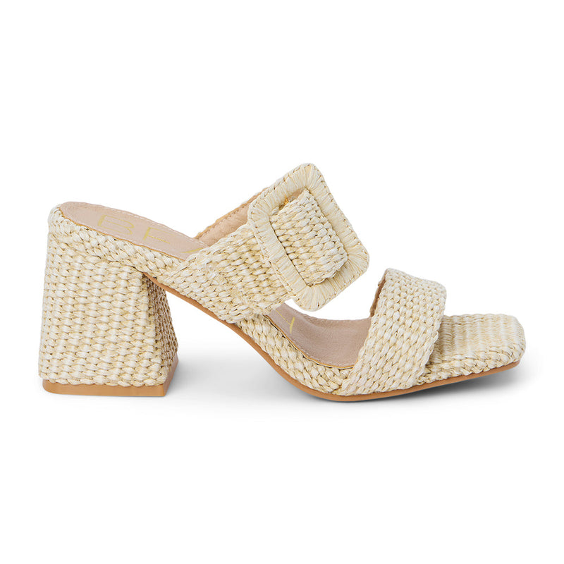 Lucy Heeled Sandal – Beach By Matisse – Beige woven heeled sandals with a bold oversized buckle detail, double strap design, and flared block heel. A playful yet polished statement piece perfect for sun-soaked days.