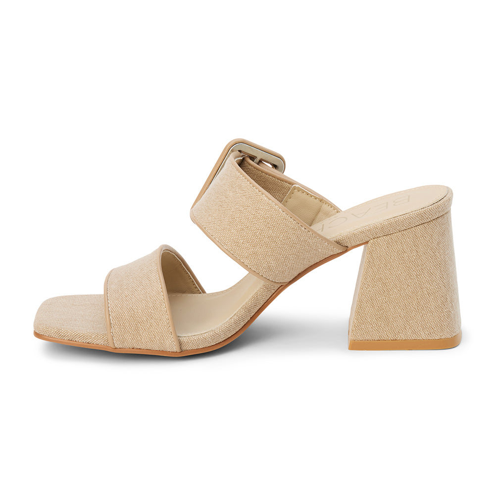 Sand textile heeled sandal with a wide textured strap, oversized buckle detail, square toe, and block heel, shown on a white background.