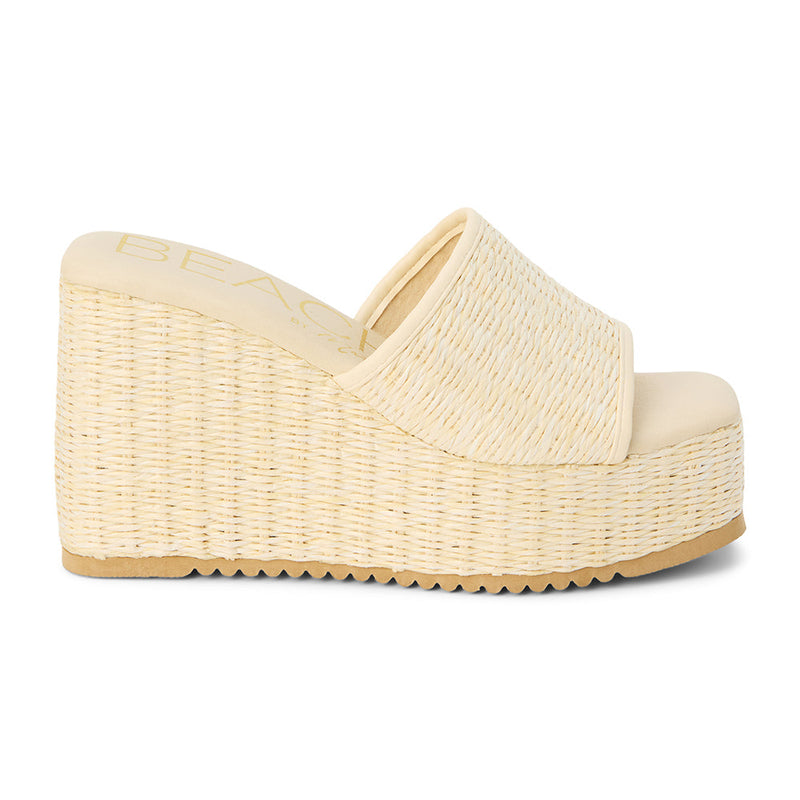 Marche Wedge Sandal – Beach By Matisse – Ivory woven raffia platform wedges with a wide single strap and sleek silhouette. A lightweight, vacation-ready style for effortless height and all-day comfort.