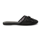 Black mesh mule with floral embellishments, slip-on design, low flat sole, and pointed toe, shown on a white background.