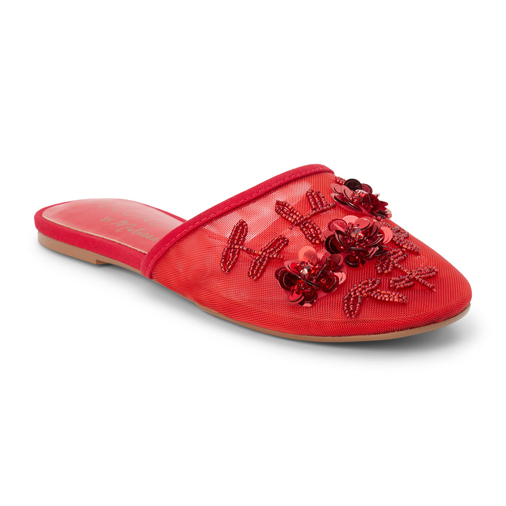 Red mesh mule with floral embellishments, slip-on silhouette, low flat sole, and pointed toe, shown on a white background.