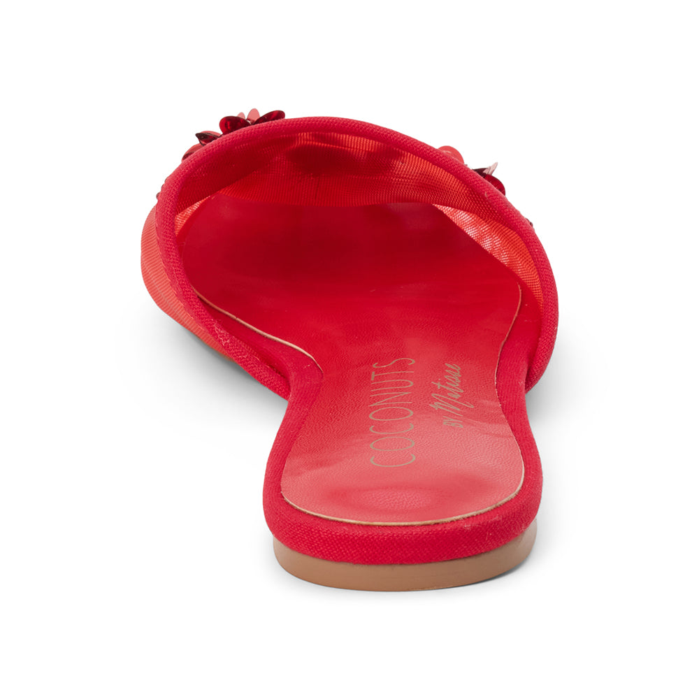Red mesh mule with floral embellishments, slip-on silhouette, low flat sole, and pointed toe, shown on a white background.