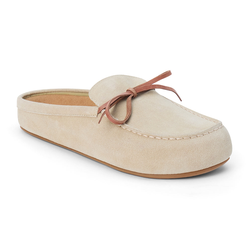 Tan suede clog with a moc-style apron toe, decorative leather bow, and backless silhouette shown on a white background.
