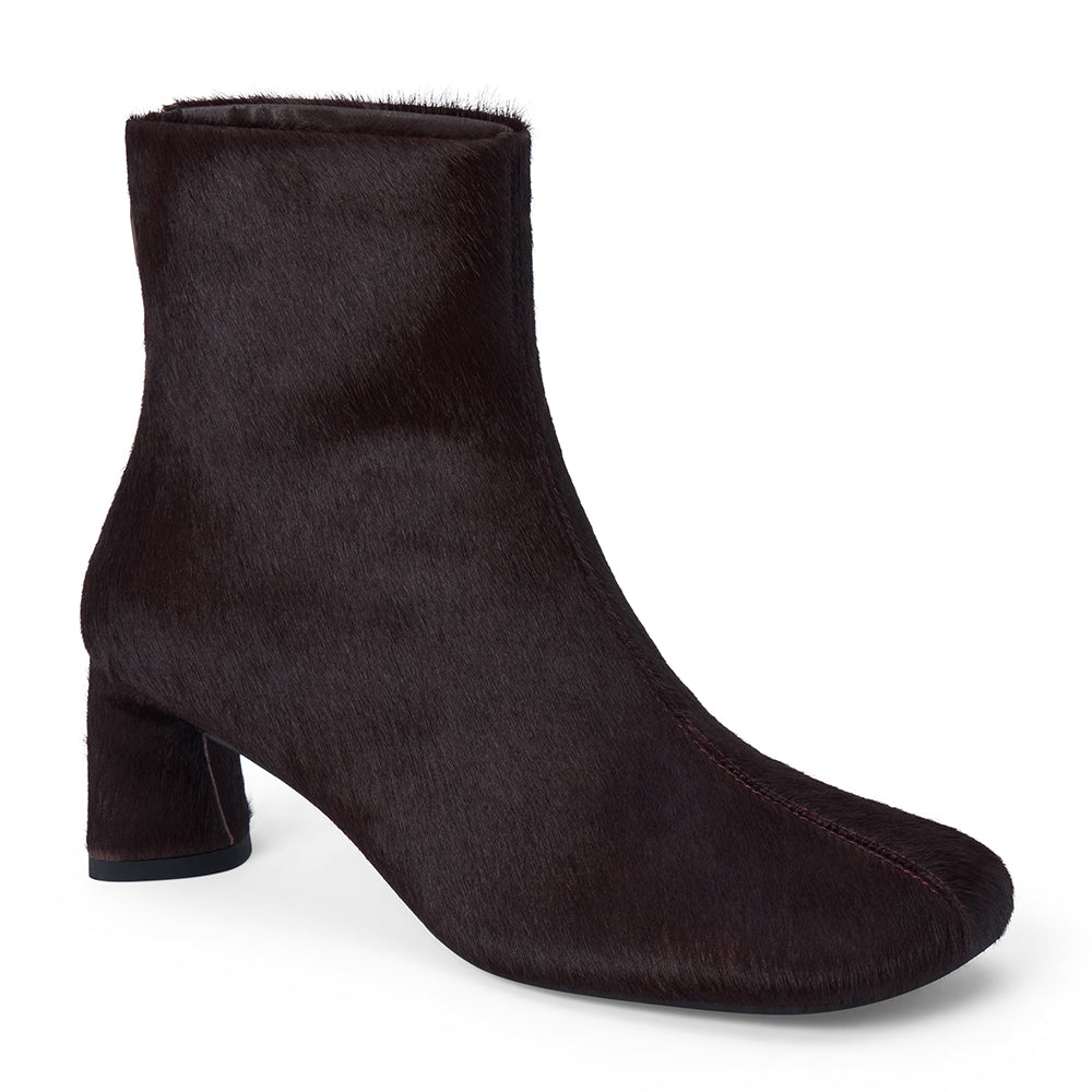 Dark purple cow hair ankle boot with a square toe, low flared heel, and side zipper shown on a white background.