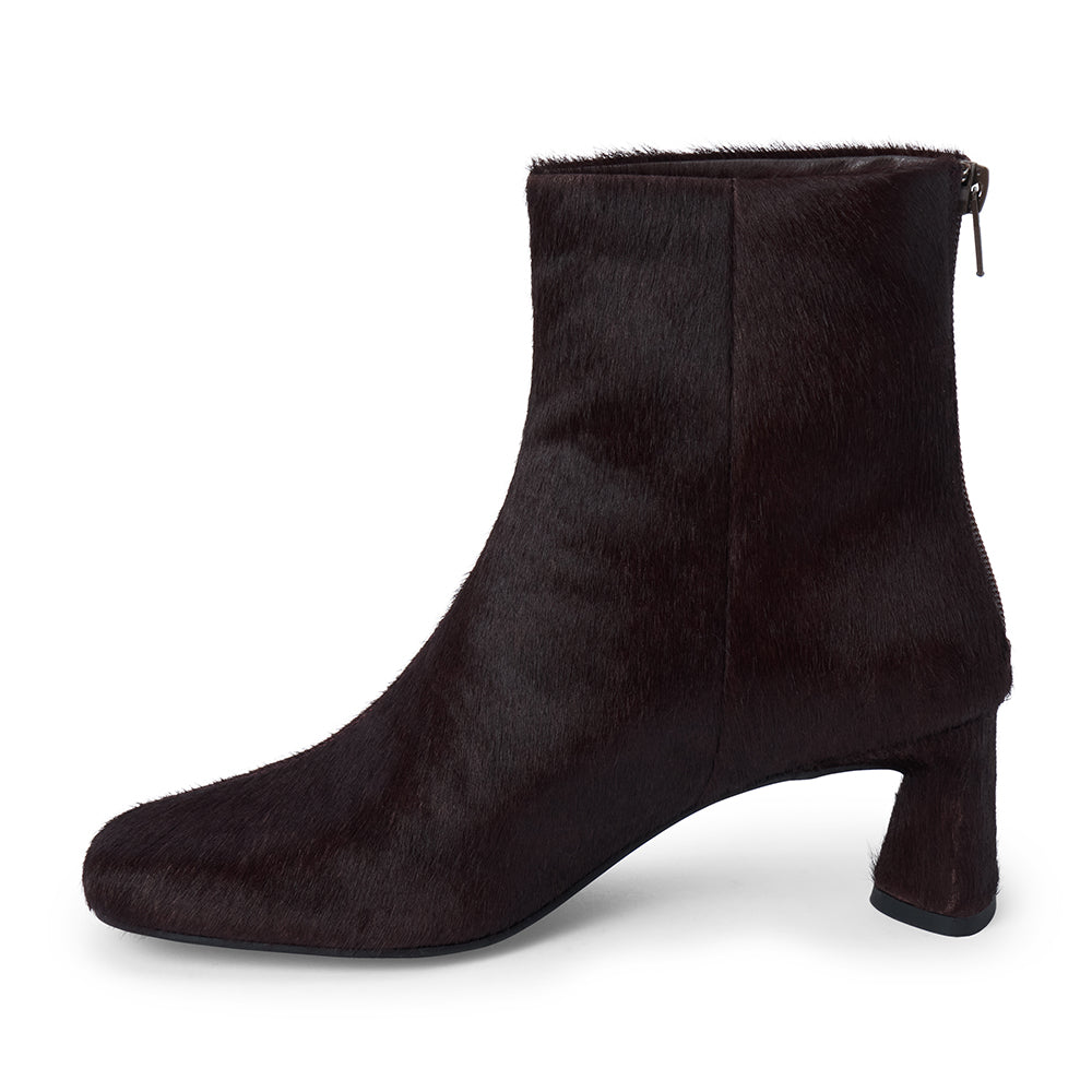 Dark purple cow hair ankle boot with a square toe, low flared heel, and side zipper shown on a white background.