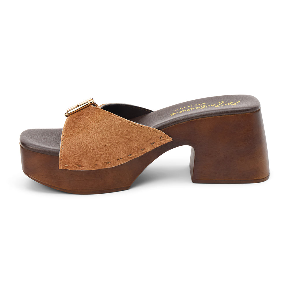 Tan cow hair platform sandal with wide buckle strap and wooden block heel, shown on a white background.