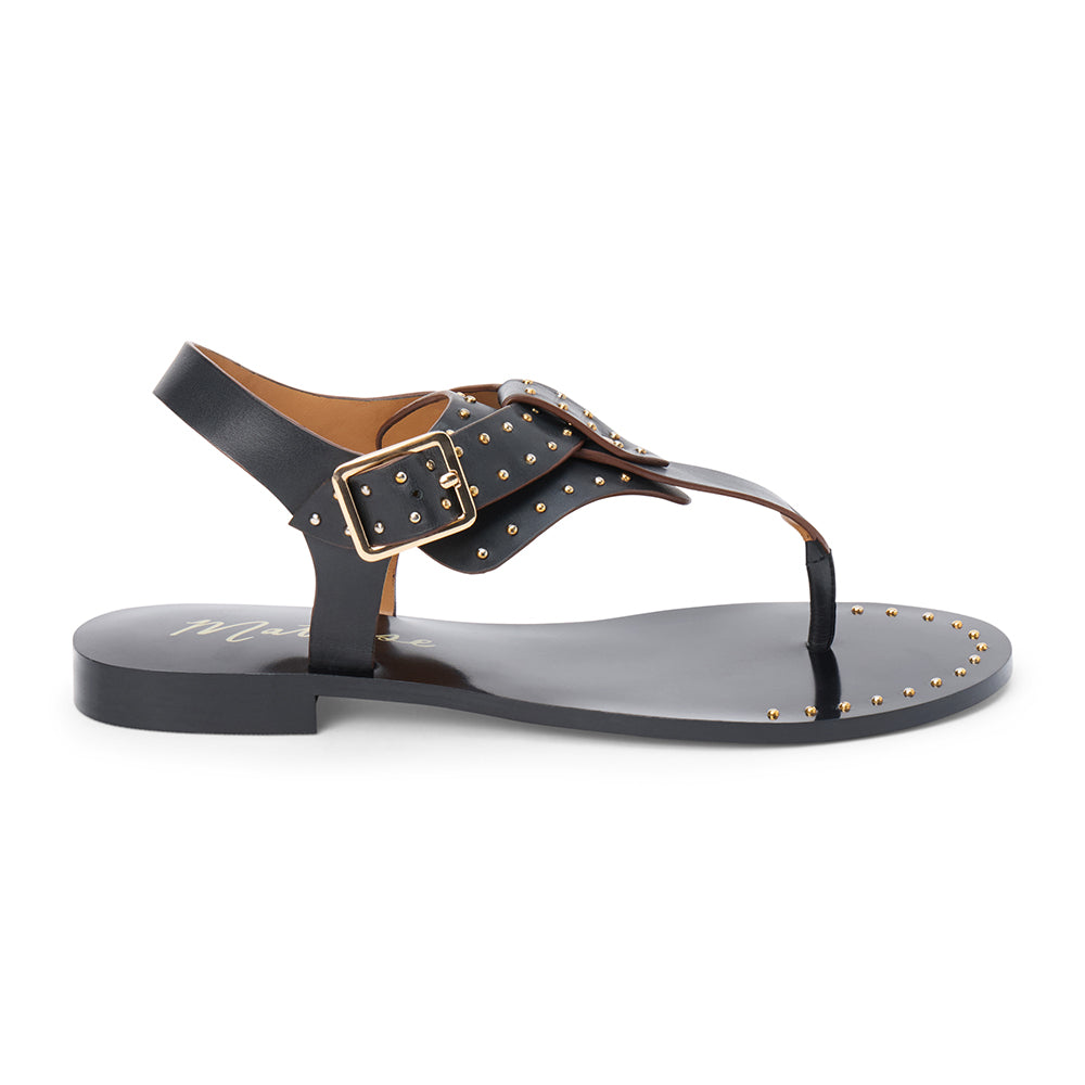 Black leather thong sandal with gold studs and buckle strap shown on a white background.
