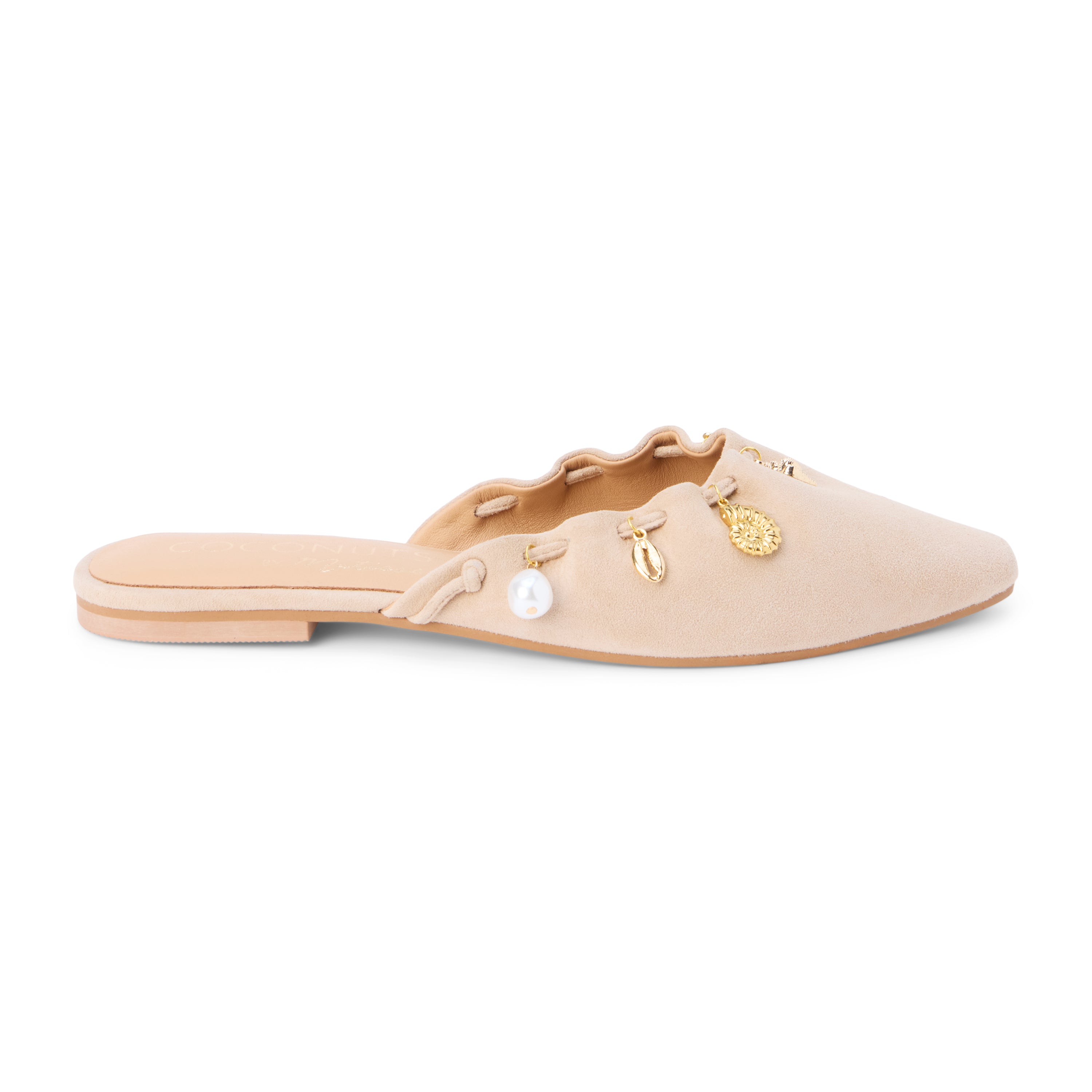 Tan suede mule with scalloped edges and decorative charms shown on a white background.