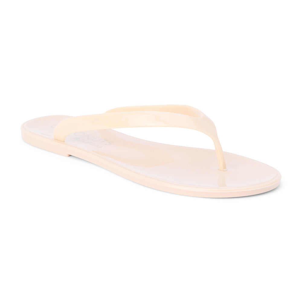 Nude PVC jelly flip flop sandal with glossy straps, open toe, and flat sole, shown on a white background.