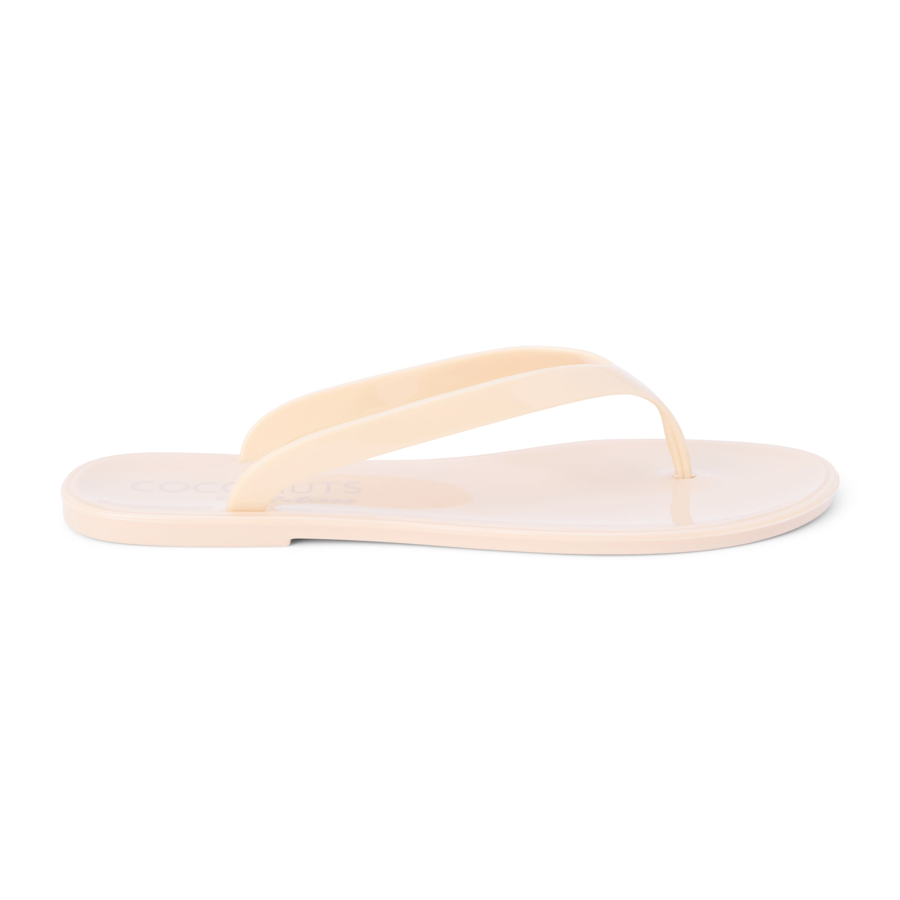 Nude PVC jelly flip flop sandal with glossy straps, open toe, and flat sole, shown on a white background.