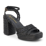 Black raffia platform sandal with woven straps, ankle buckle, and block heel, shown on a white background.