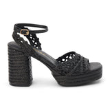 Black raffia platform sandal with woven straps, ankle buckle, and block heel, shown on a white background.