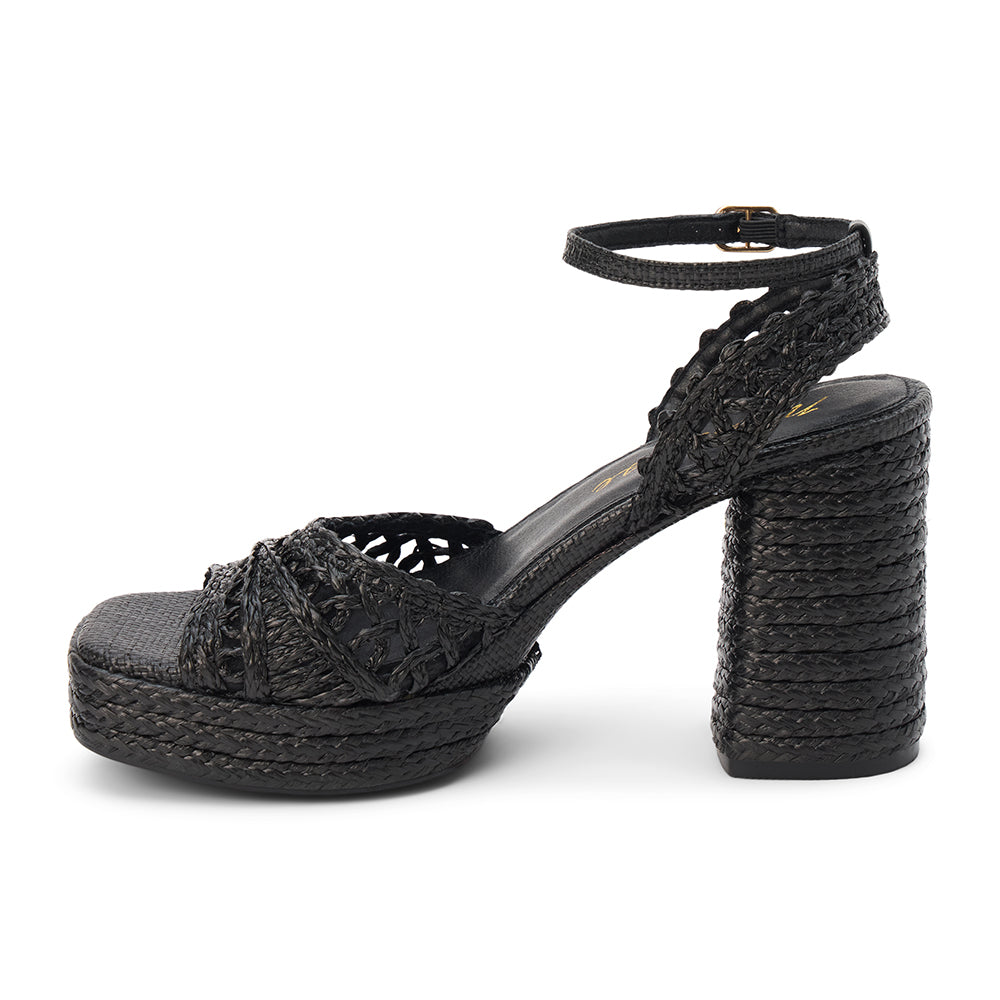 Black raffia platform sandal with woven straps, ankle buckle, and block heel, shown on a white background.