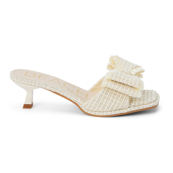 Penelope Heeled Sandal – Beach By Matisse – Cream raffia kitten heels with a flared heel and oversized layered bow detail. A playful yet polished slide for garden parties, brunches, and summer soirées.