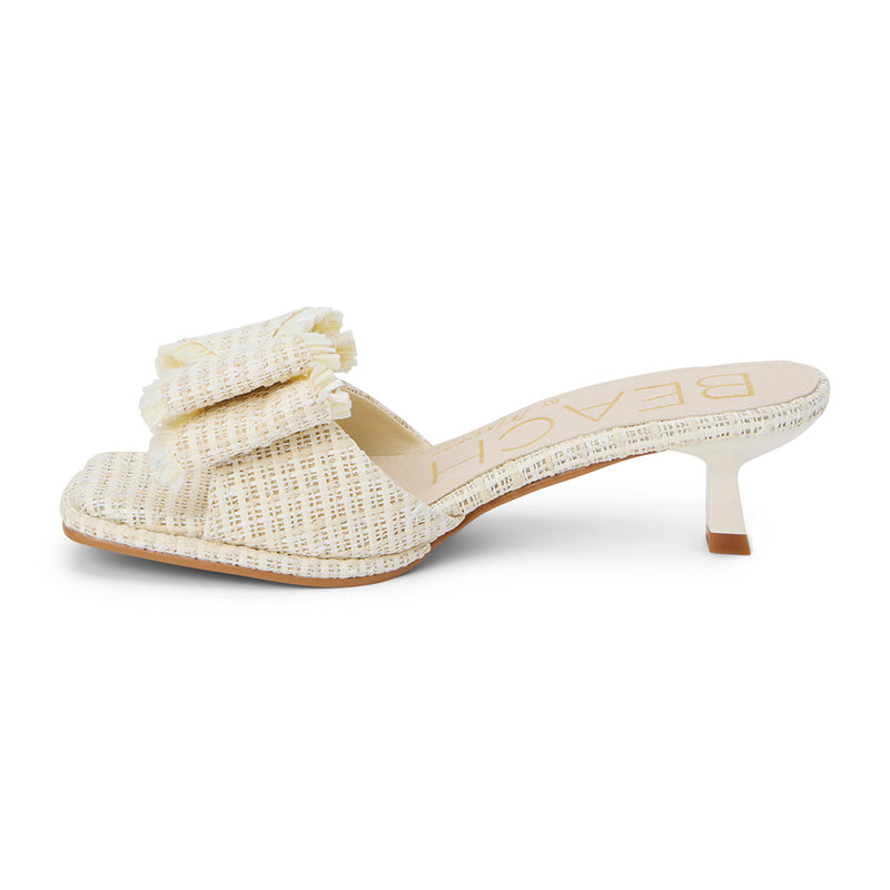 Penelope Heeled Sandal – Beach By Matisse – Cream raffia kitten heels with a flared heel and oversized layered bow detail. A playful yet polished slide for garden parties, brunches, and summer soirées.