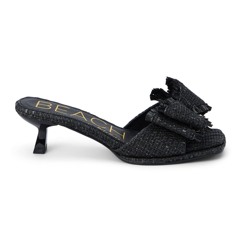 Penelope Heeled Sandal – Beach By Matisse – Black raffia kitten heels with a flared heel and oversized layered bow detail. A playful yet polished slide for garden parties, brunches, and summer soirées.