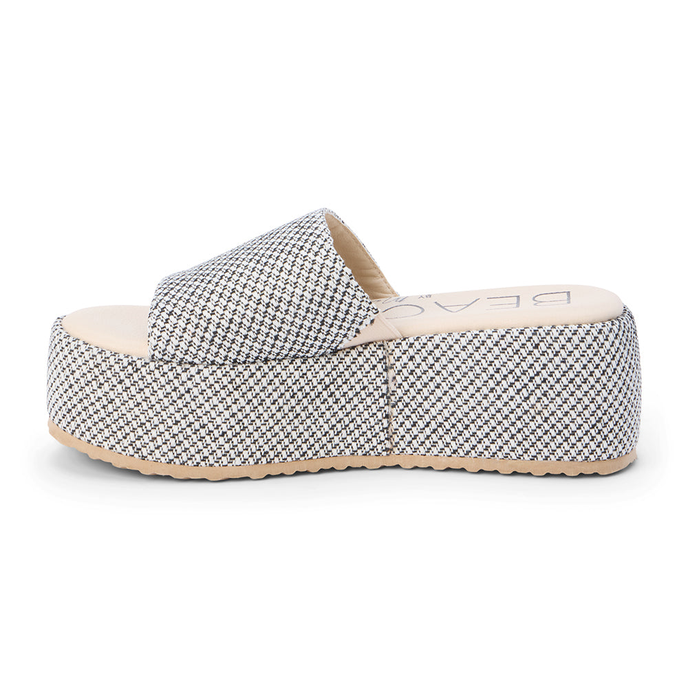 White and black jute platform slide sandal with a wide woven strap and flatform sole, shown on a white background.