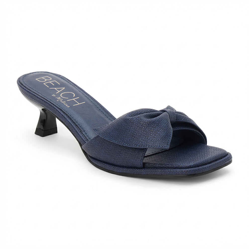 Navy vegan faux leather heeled sandal with knotted bow detail and slim heel, shown on a white background.