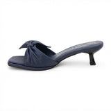 Navy vegan faux leather heeled sandal with knotted bow detail and slim heel, shown on a white background.