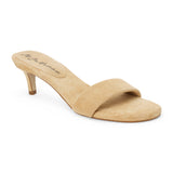 Beige suede slide sandal with wide strap and low kitten heel, shown on a white background.