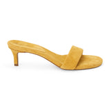 Yellow suede slide sandal with wide strap and low kitten heel, shown on a white background.