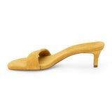 Yellow suede slide sandal with wide strap and low kitten heel, shown on a white background.