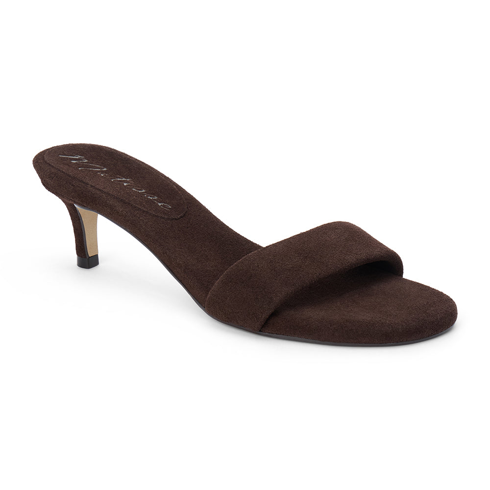 Brown suede slide sandal with wide strap and low kitten heel, shown on a white background.