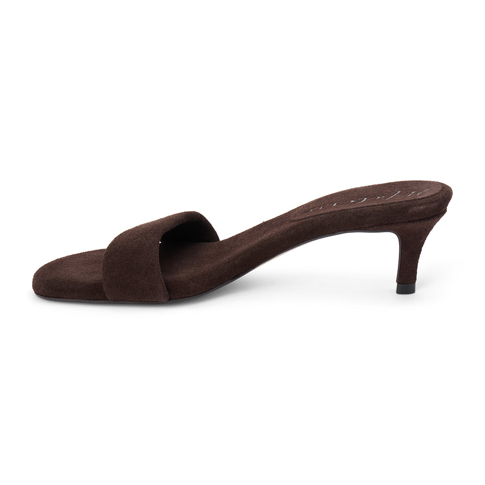 Brown suede slide sandal with wide strap and low kitten heel, shown on a white background.