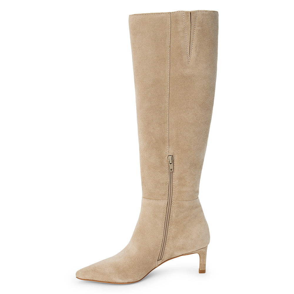 Tan suede knee-high boot with four silver-tone buckle accents, a pointed toe, and slim tan kitten heel shown on a white background.